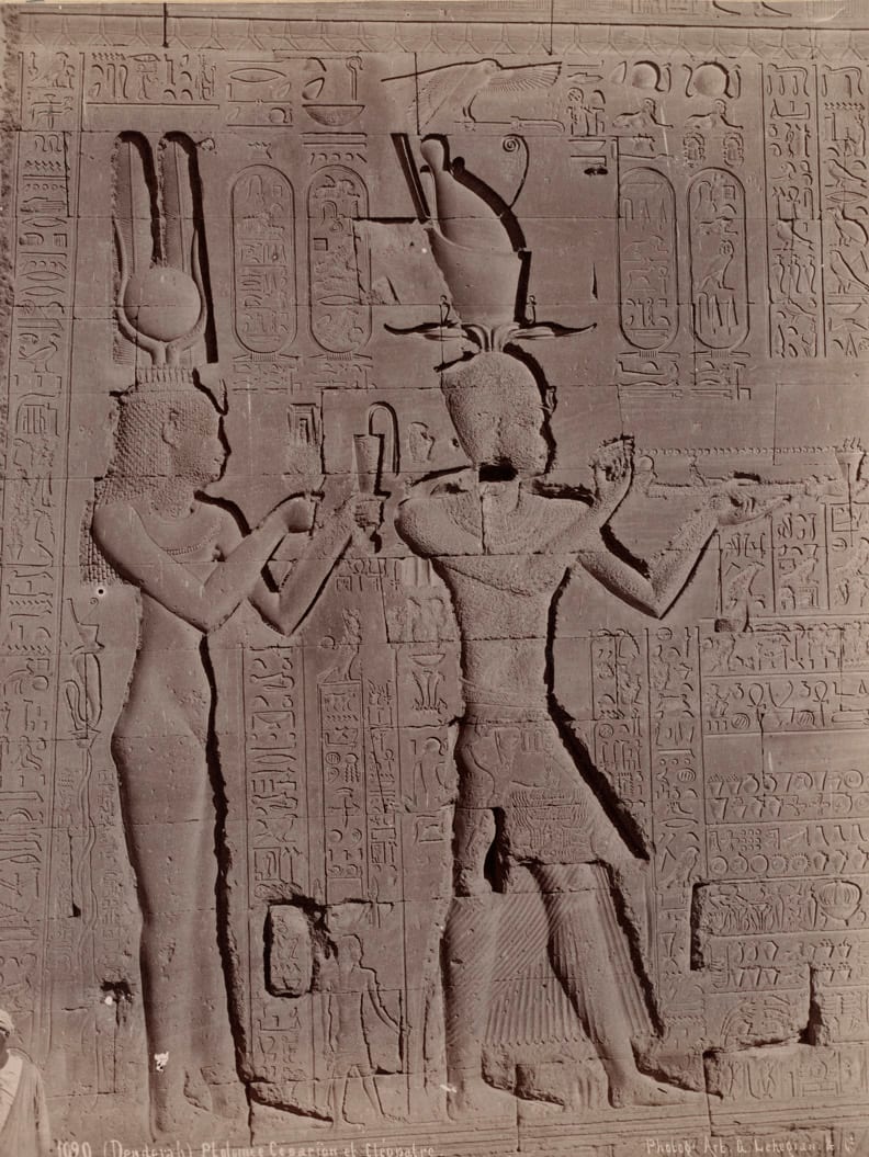 Relief gravé sur un mur de temple montrant deux personnages faisant une offrande