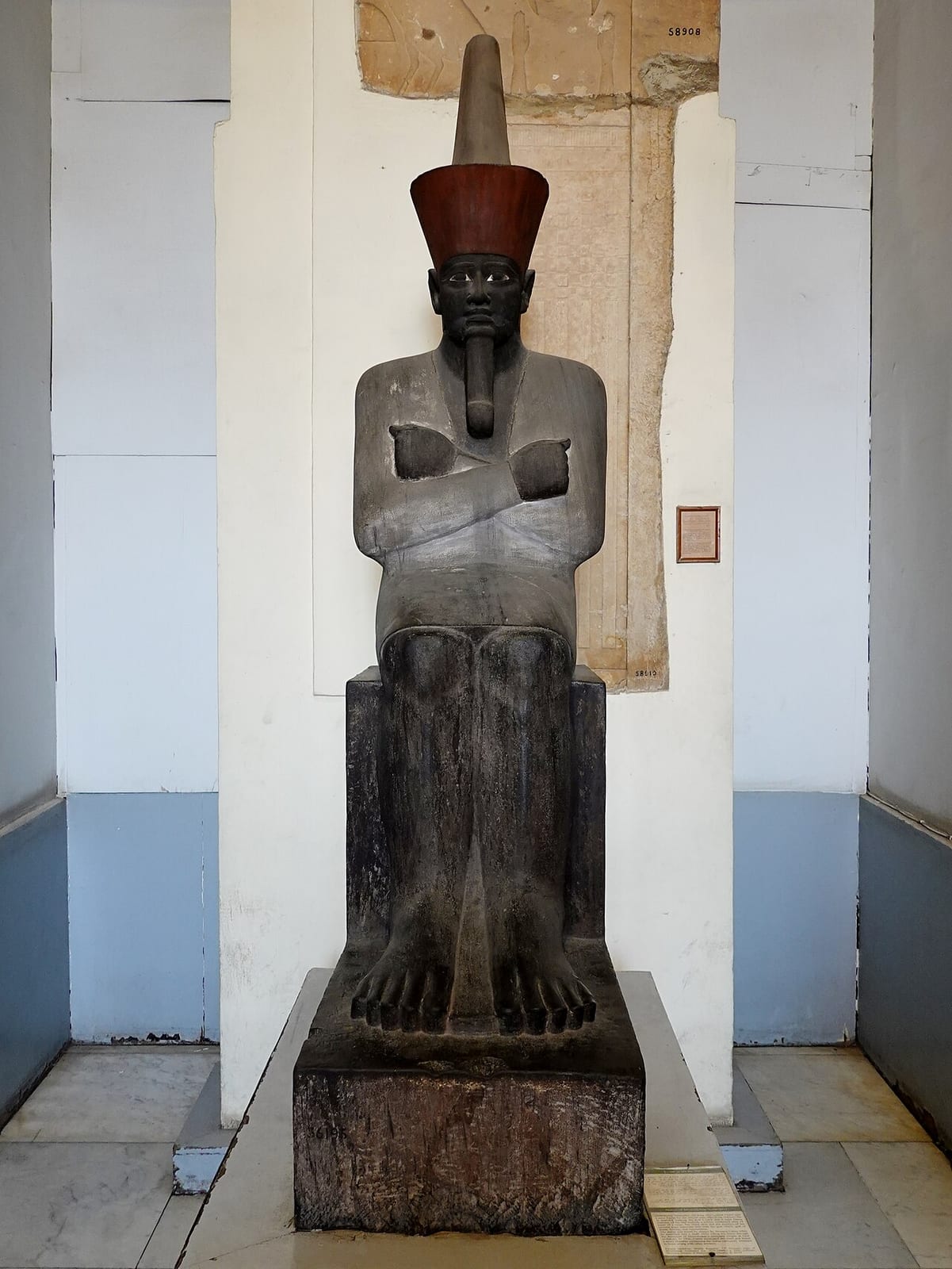 Statue de pharaon assis, à la peau noire et vêtu d'un pagne blanc