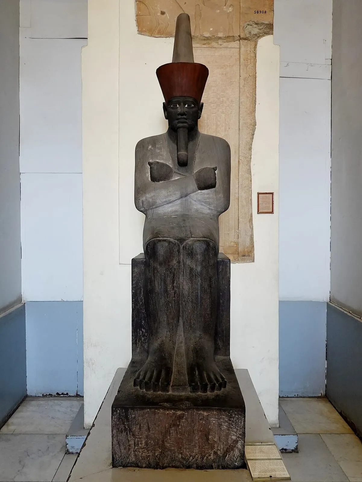 Statue de pharaon assis, à la peau noire et vêtu d'un pagne blanc