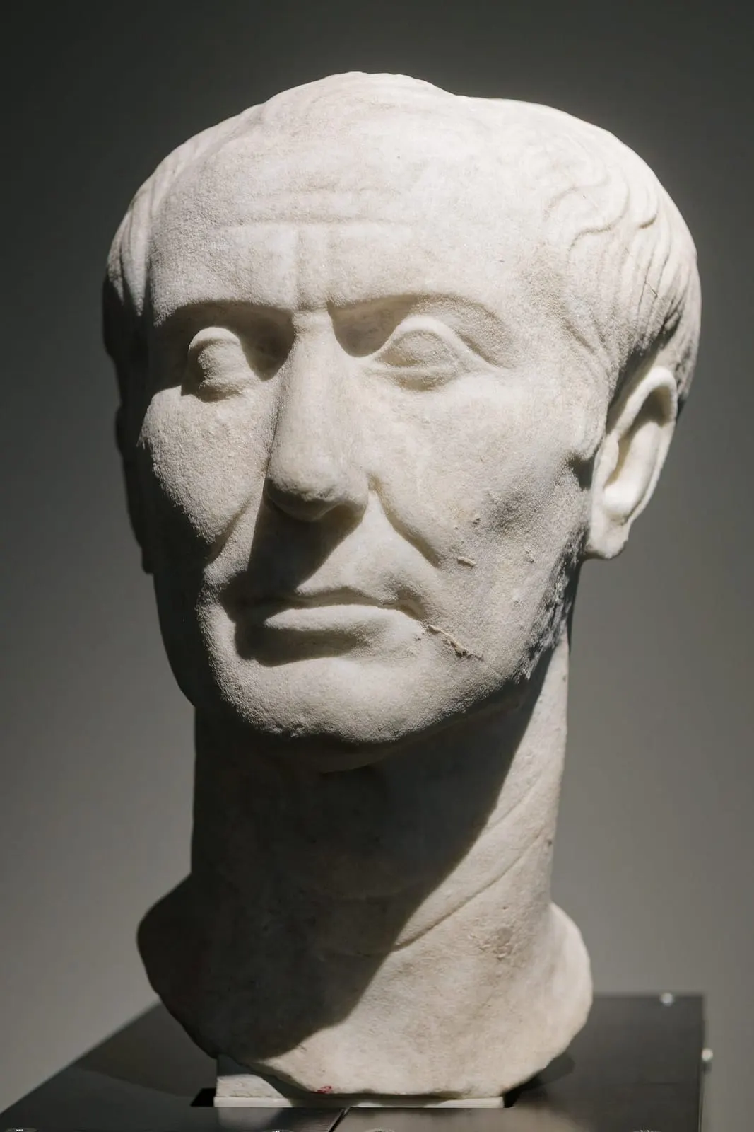 Tête sculptée en marbre d'un homme au crâne dégarni et au visage marqué, portrait de Jules César