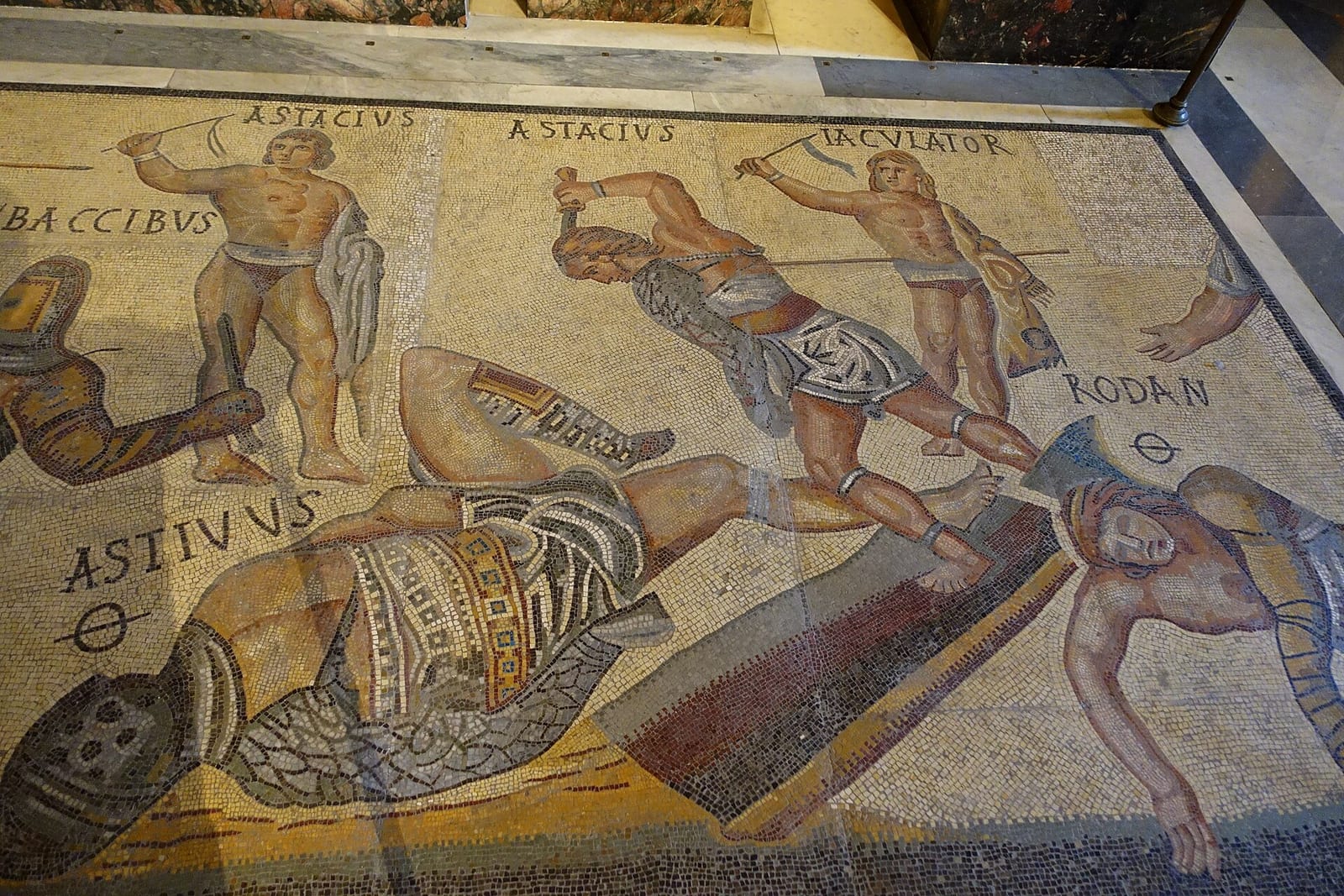 Mosaïque romaine montrant des gladiateurs en combat, avec leurs noms inscrits