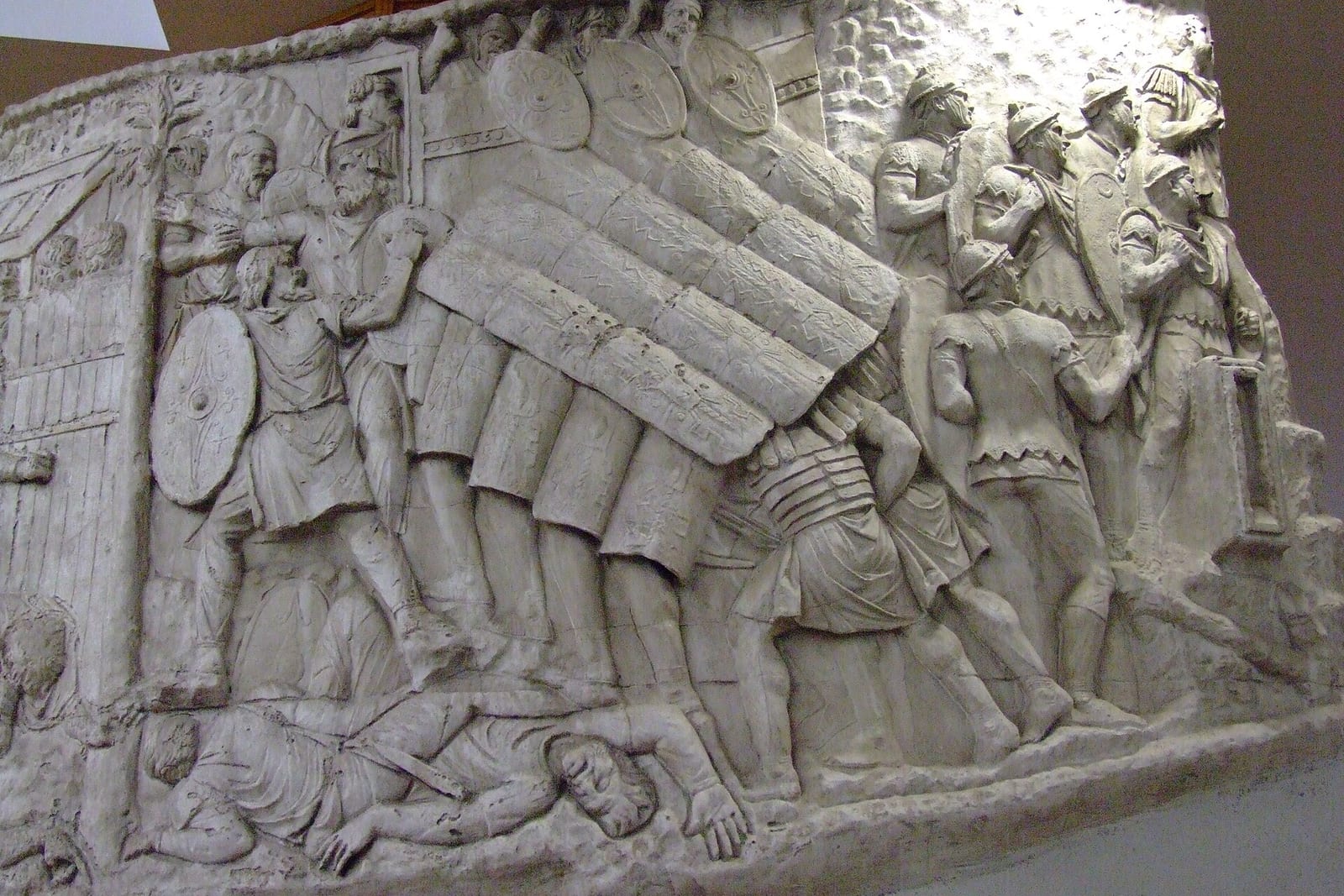 Relief antique montrant des soldats romains abrités sous un toit de boucliers
