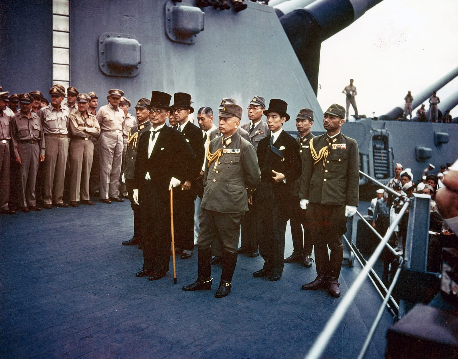 Délégation japonaise en tenue officielle sur le pont d'un cuirassé, entourée de militaires américains