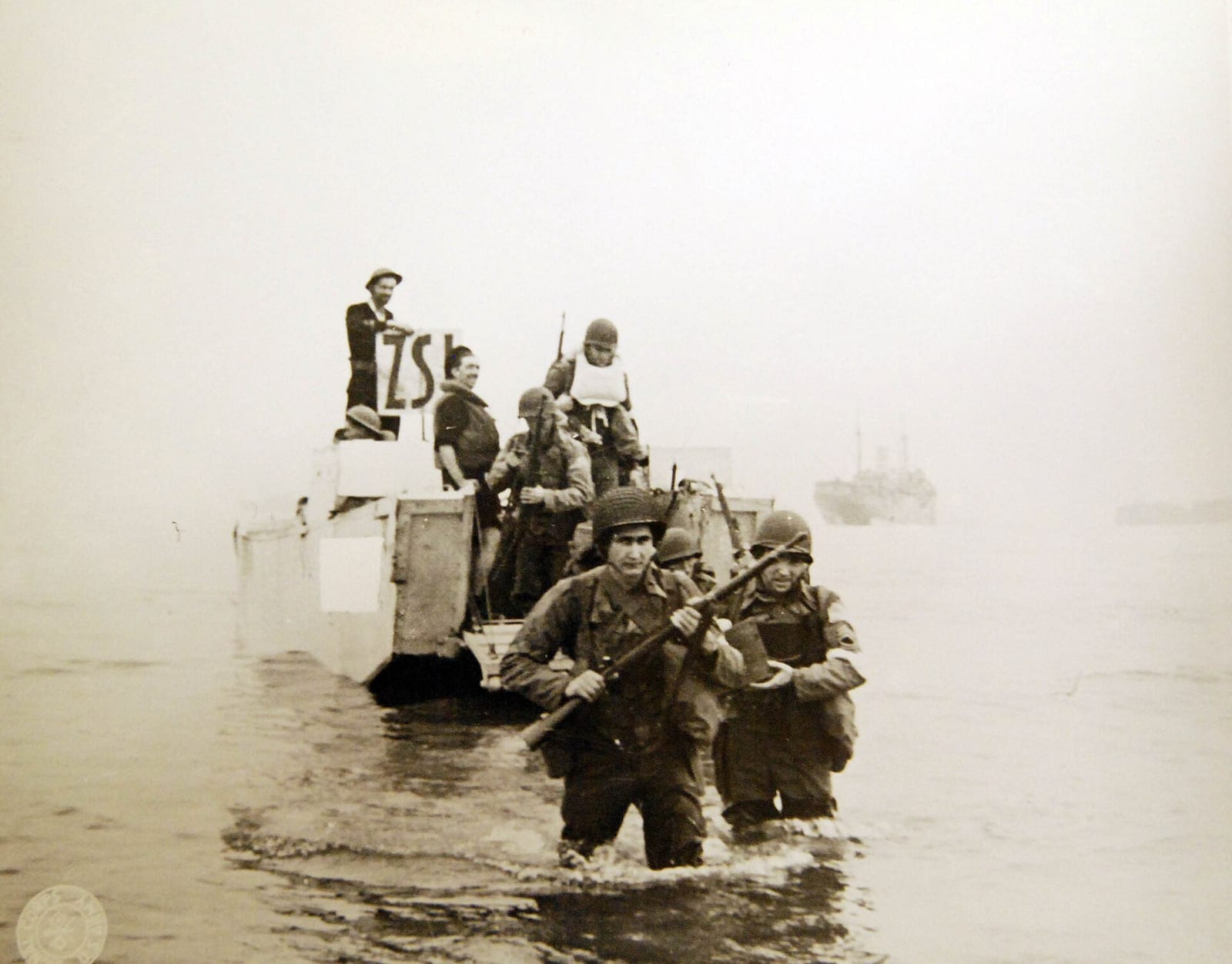 Soldats armés débarquant d'une barge et avançant dans l'eau vers une plage