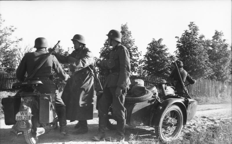 Soldats allemands en uniforme près d'une moto avec side-car, dans la campagne russe