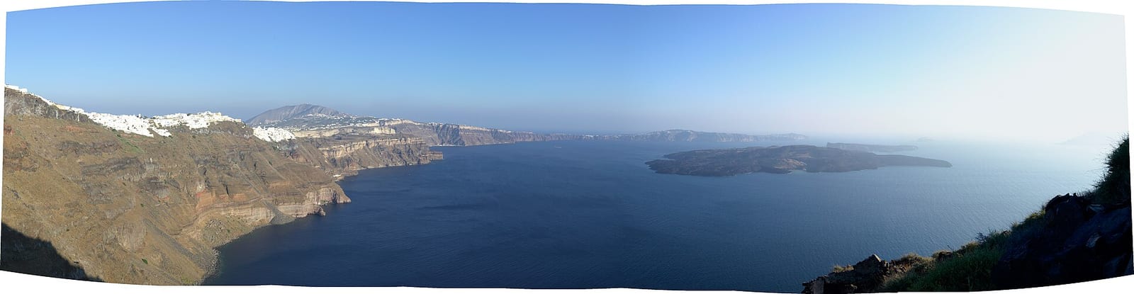 Vue panoramique de la caldeira de Santorin, immense cirque marin entouré de falaises
