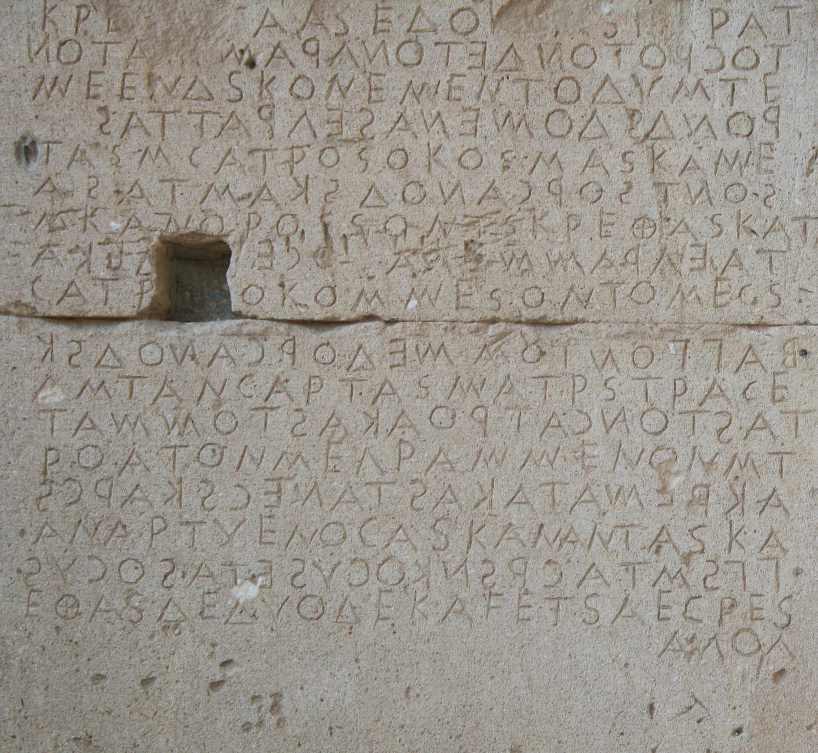 Mur de pierre couvert de lignes de lettres grecques gravées