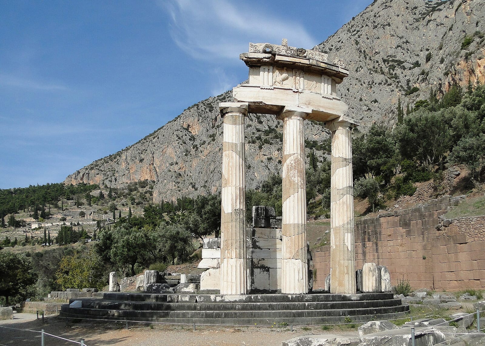 Édifice circulaire antique dont trois colonnes ont été relevées, dans un paysage de montagne