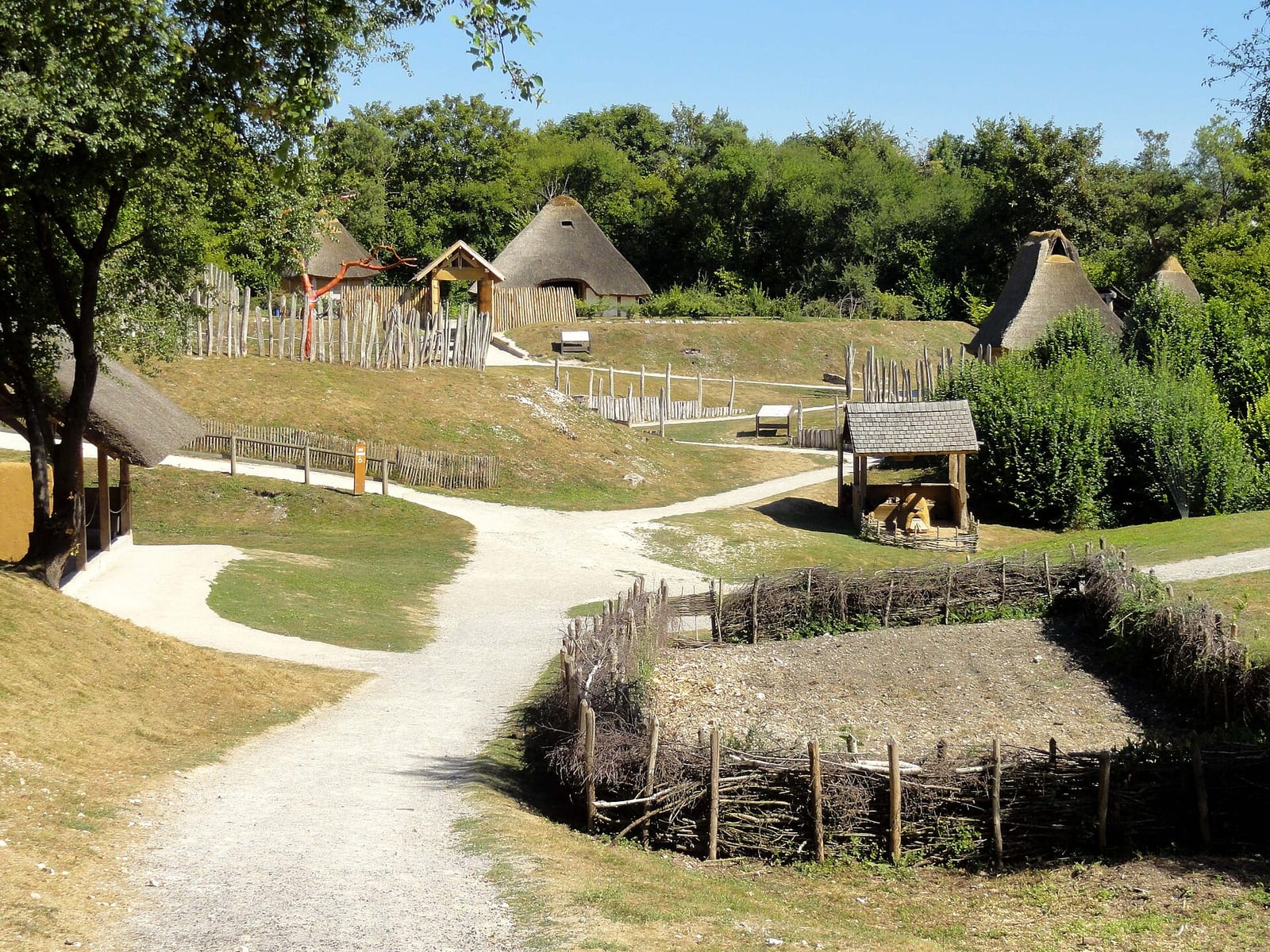 Maisons rondes au toit de chaume reconstituées dans un parc archéologique