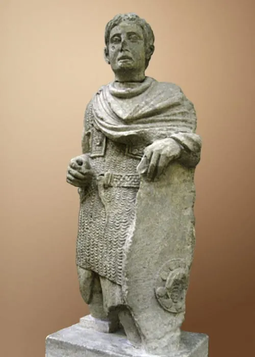 Statue de pierre d'un guerrier gaulois en cotte de mailles, portant un torque et un bouclier