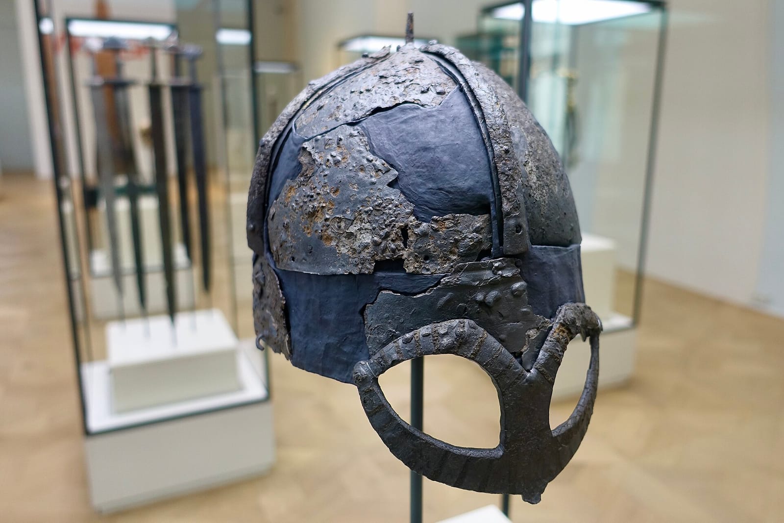 Casque de fer arrondi muni d'un masque protégeant les yeux et le nez, présenté en vitrine