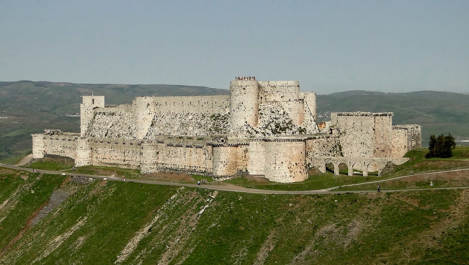 Vaste forteresse de pierre à double enceinte, dominant une colline