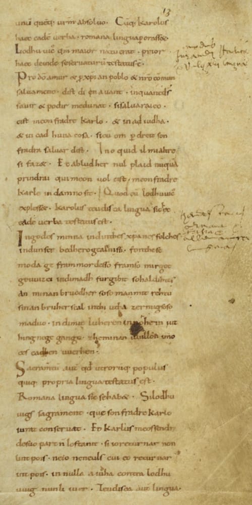 Page de manuscrit médiéval couverte d'une écriture serrée, avec des annotations en marge