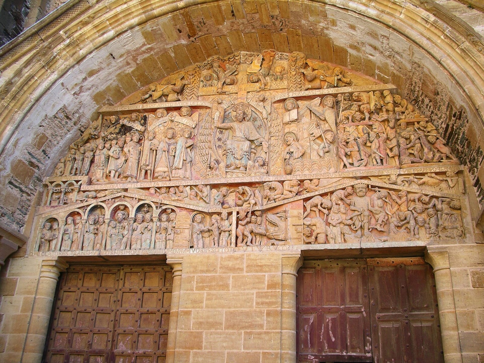 Tympan sculpté au-dessus d'un portail d'église, couvert de dizaines de personnages